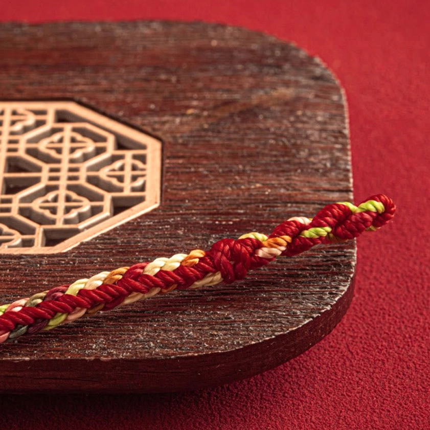Detailed view of braided multicolored rope segments showing the intricate weaving pattern of Buddhist lucky bracelet