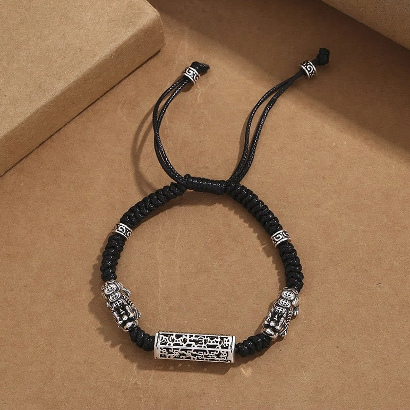 Flat lay top view of black Om Mani Padme Hum Buddhist bracelet with copper accents fully displayed