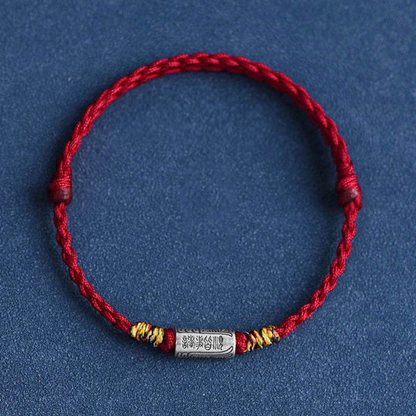 Handcrafted Buddhist protection bracelet featuring engraved spiritual characters on silver charm, premium rope quality showcase