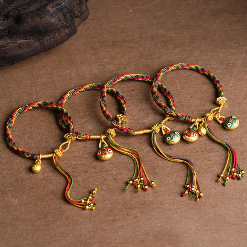 Buddhist protection string bracelet with gold swallowing beast charm and multi-color spiritual weaving design