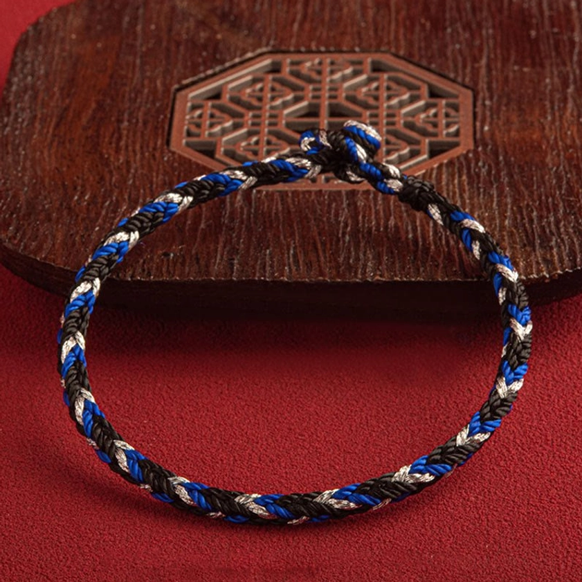 Wrist-level perspective of multicolored Buddhist string bracelet with protective King Kong knot fastener