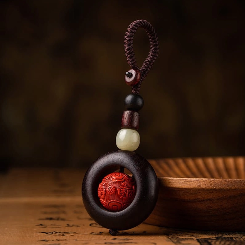 Complete Buddhist keychain with stacked beads assembly and rope lanyard, three-quarter front view on vintage paper background