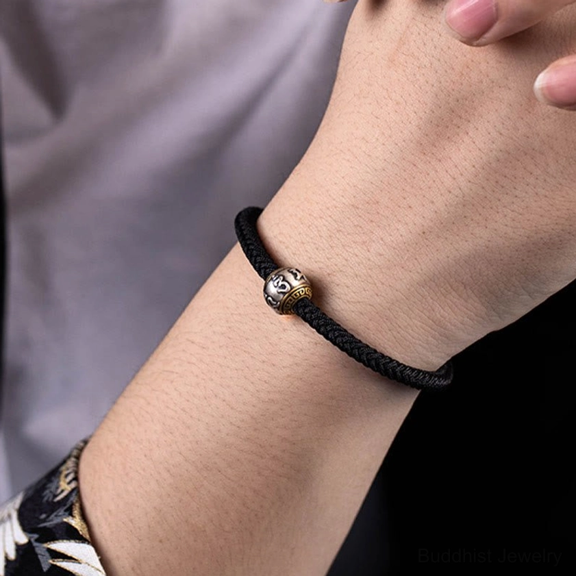 Buddhist protection and luck bracelet featuring red braided rope, sterling silver pendant, and traditional slip-knot fastening