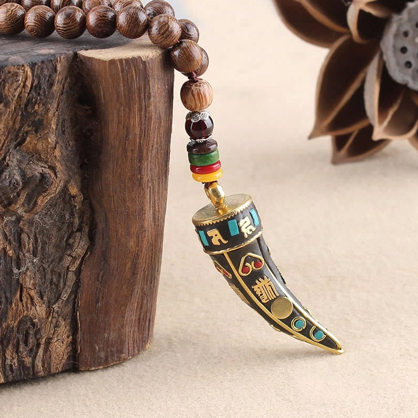 Buddhist necklace protection pendant close-up with engraved sacred text patterns