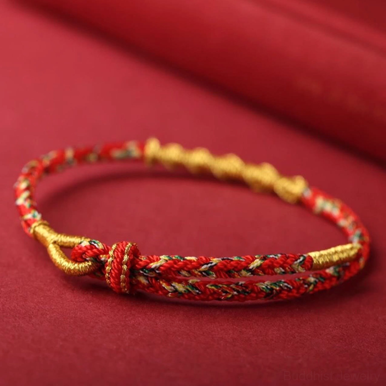 Red black and gold Buddhist protection bracelet with traditional Chinese knot clasp and woven cord design