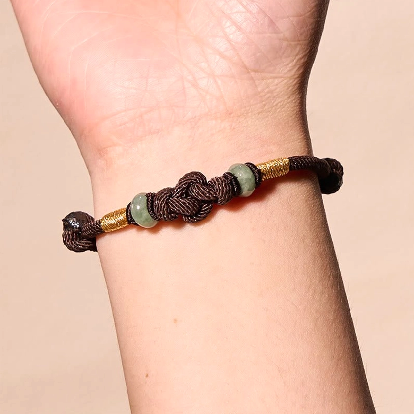 Buddhist protective red string jade bracelet detail showing blessed cord and natural stone beads for spiritual practice