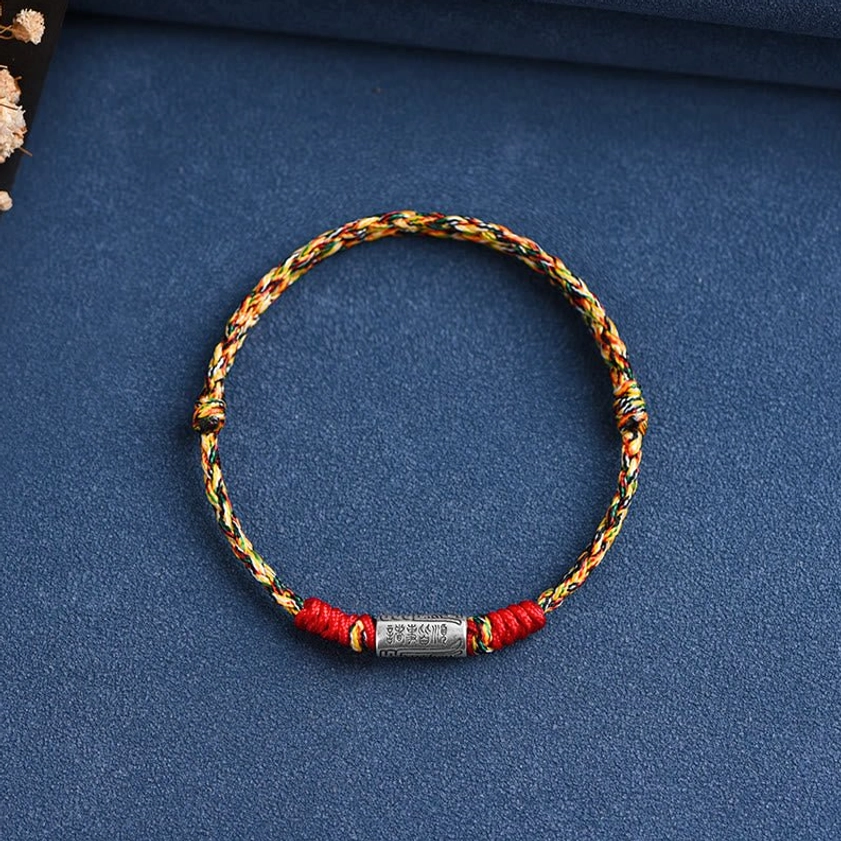 Buddhist blessing bracelet with rainbow multicolor rope and 925 sterling silver charm, celebrating spiritual diversity and colorful protection