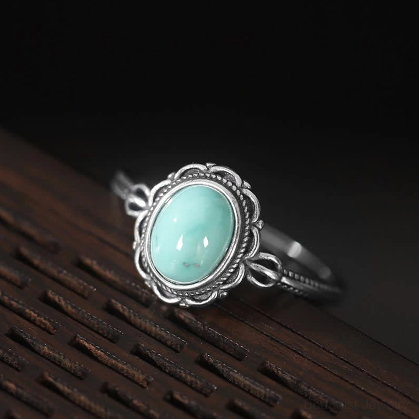 925 sterling silver Buddhist red agate ring with filigree setting on blue fabric background