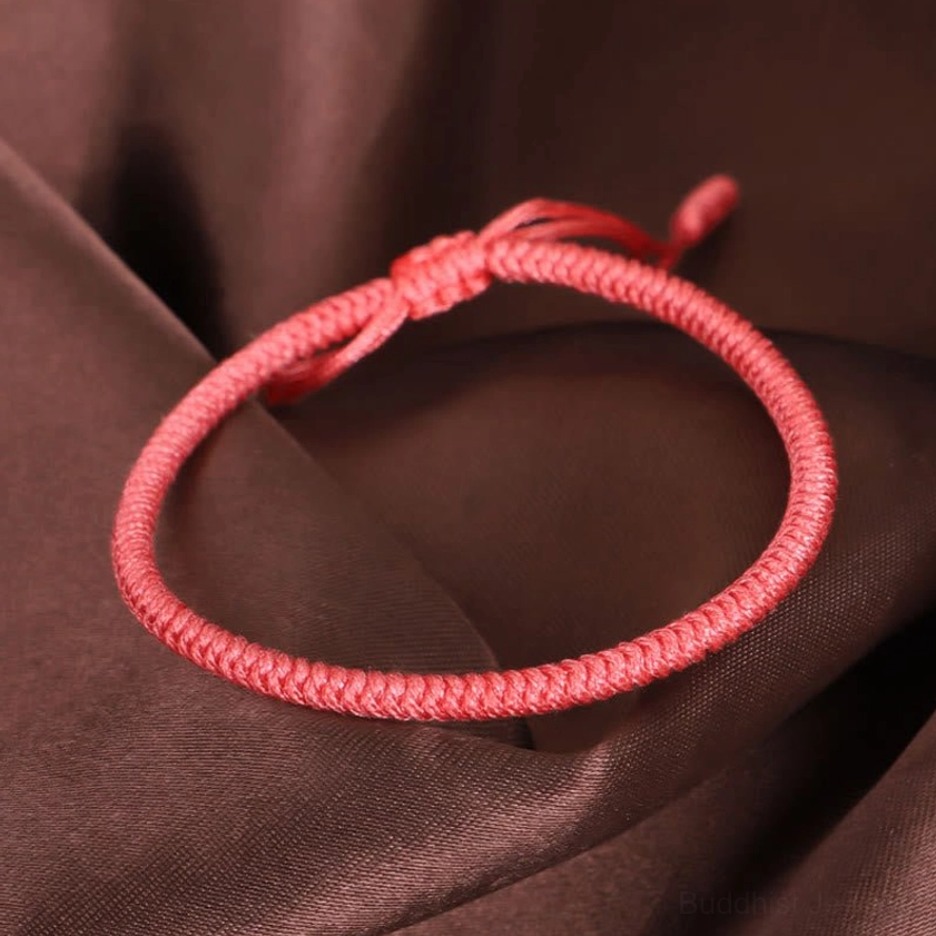 Single-strand solid red Buddhist bracelet with twisted woven rope texture and slip knot closure for adjustable fit
