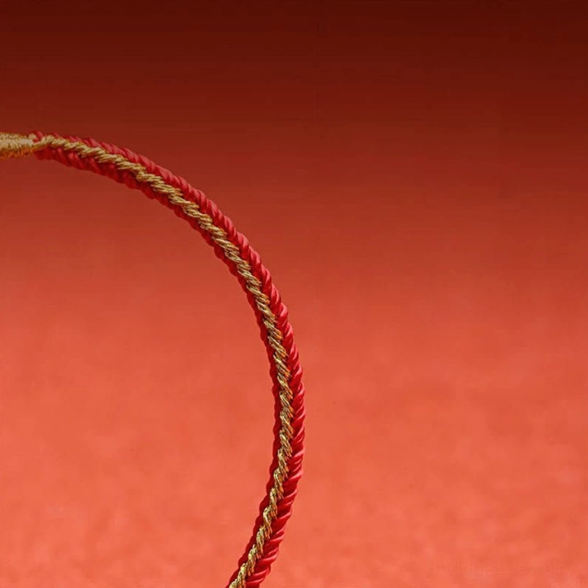 Single red twisted braided Buddhist protection cord on matte background