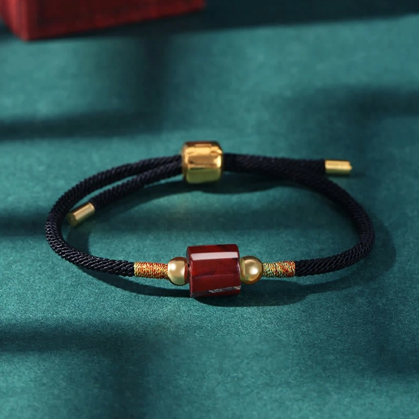 Red stone Buddhist bracelet with black braided rope and adjustable sliding clasp for spiritual grounding
