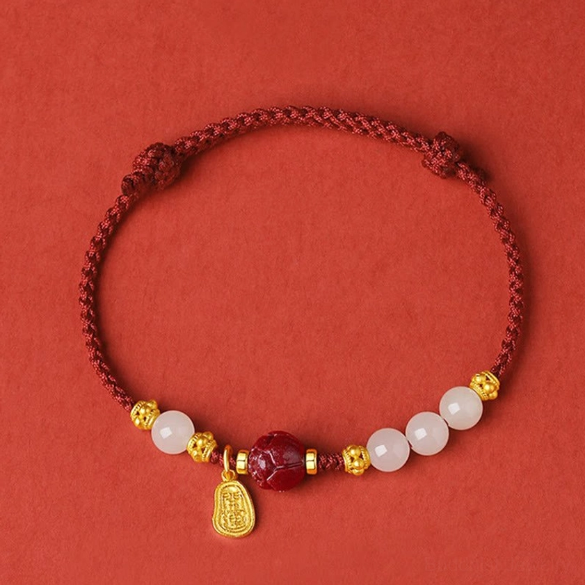 Buddhist red string bracelet with adjustable sliding knot, flat lay overhead view on red background