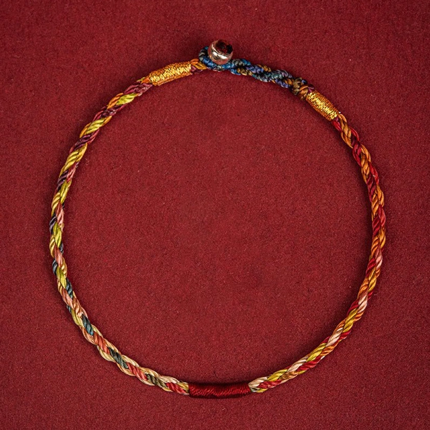 Front flat lay of five-color Buddhist lucky bracelet showing round metal clasp and full twisted rope