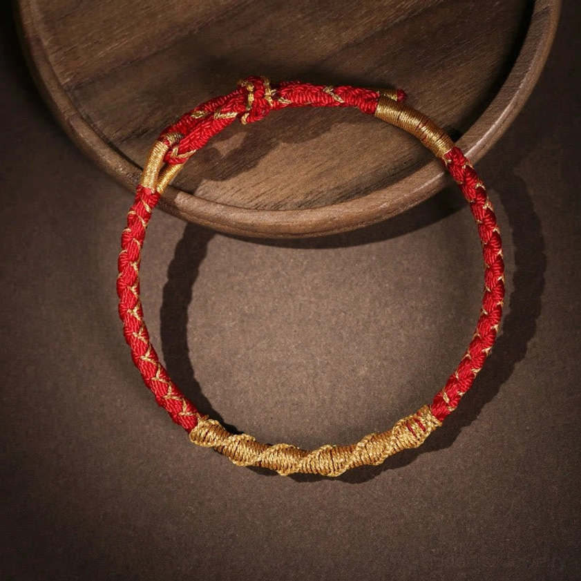 Red Buddhist string bracelet top view showing intricate woven braid texture and adjustable knot detail