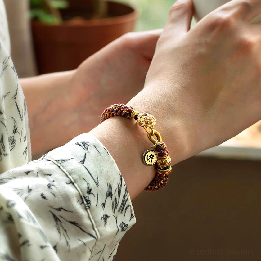 Red string Buddhist bracelet worn on wrist showing daily wear comfort and multicolor braided cord design
