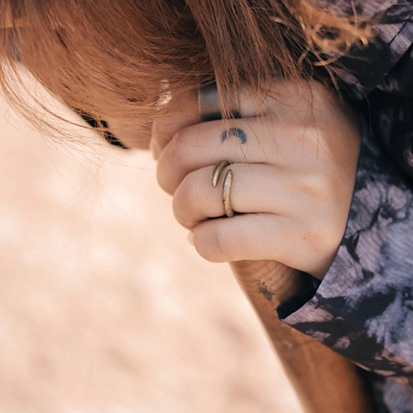 Spiral copper rings on hand with crescent tattoo, casual styled jewelry wear