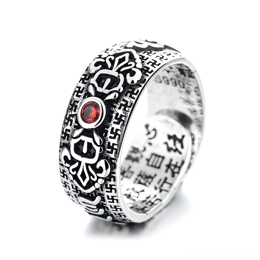 Three-quarter view of Buddhist copper ring with Heart Sutra engravings on inner band, vintage silver patina, and natural ruby stone under studio light