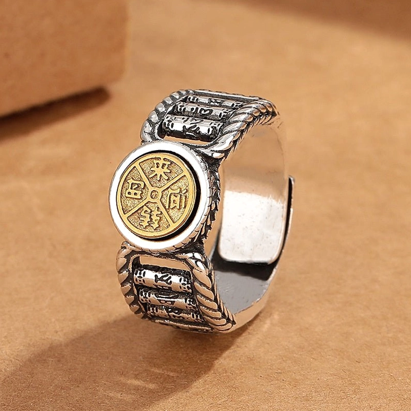 Buddhist mantra ring worn on finger showing two-tone vintage metal design in real-world wear