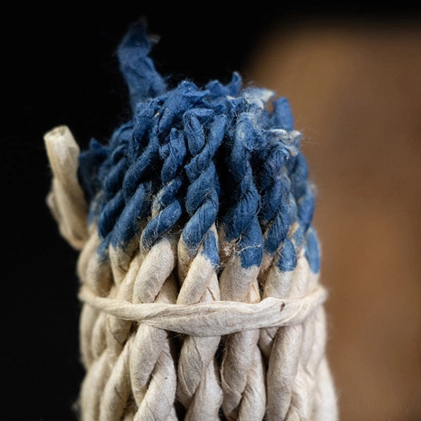 Extreme close-up of Buddhist rope incense showing blue-dyed rope ends, thick twisted natural fibers bound with traditional twine, demonstrating handcrafted artisan quality