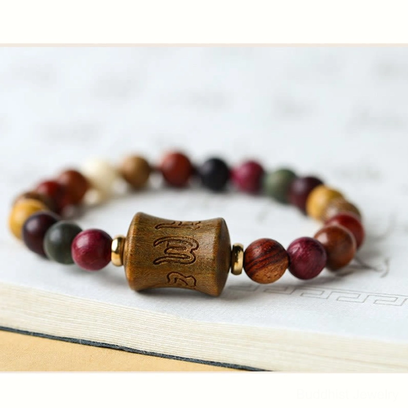 Buddhist prayer bracelet featuring multicolor sandalwood beads and carved Om Mani Padme Hum mantra focal bead