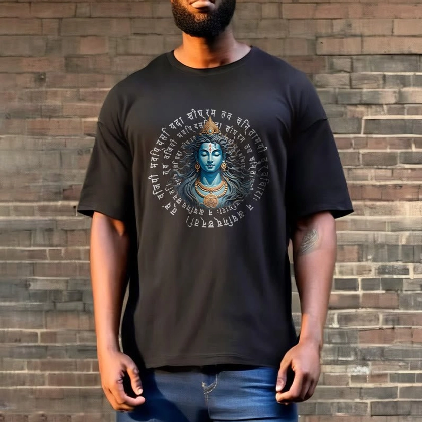 Man wearing black Buddhist mantra tee with blue jeans - full upper body view against brick wall background