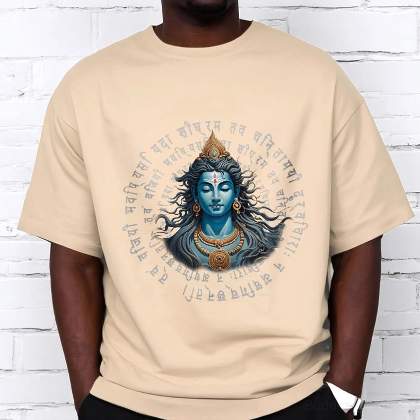 Man in khaki Buddhist mantra tee with black pants - front view against white brick wall background