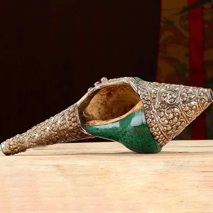Buddhist conch shell with open shell mouth showing inner brown natural conch, revealing silver carved outer decorative layer and dorje symbol