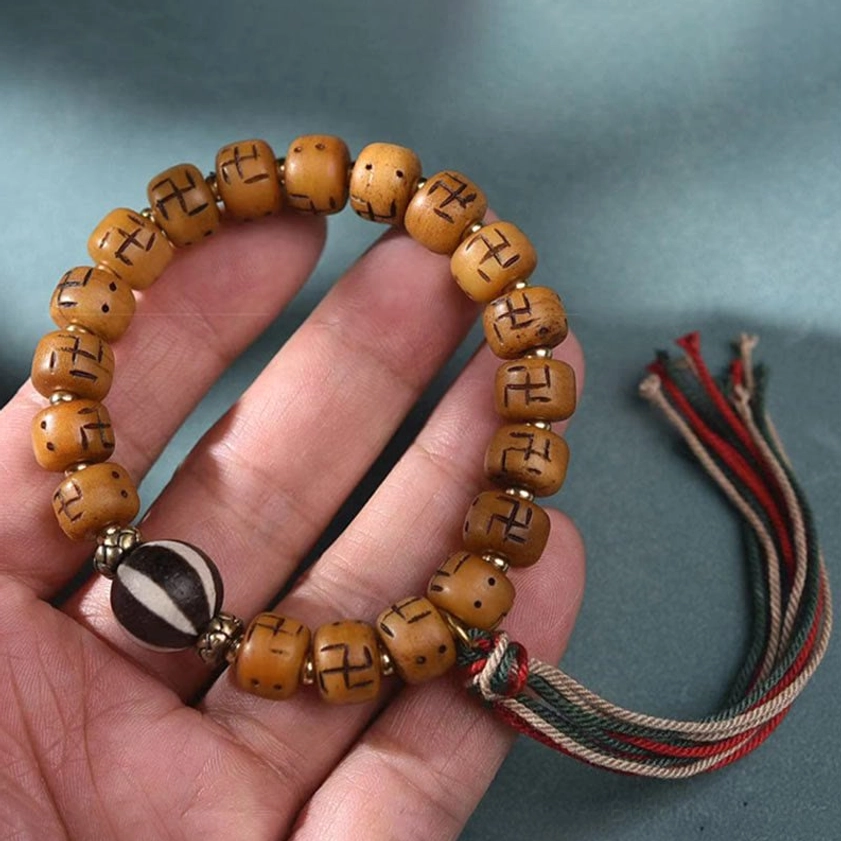 Traditional Buddhist Shankha tassel bracelet with carved bone beads, conch symbol, and spiritual pendant