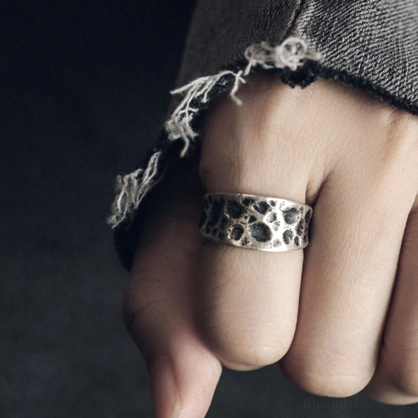 Buddhist protection ring worn on hand showing aged silver patina and natural texture in everyday wear