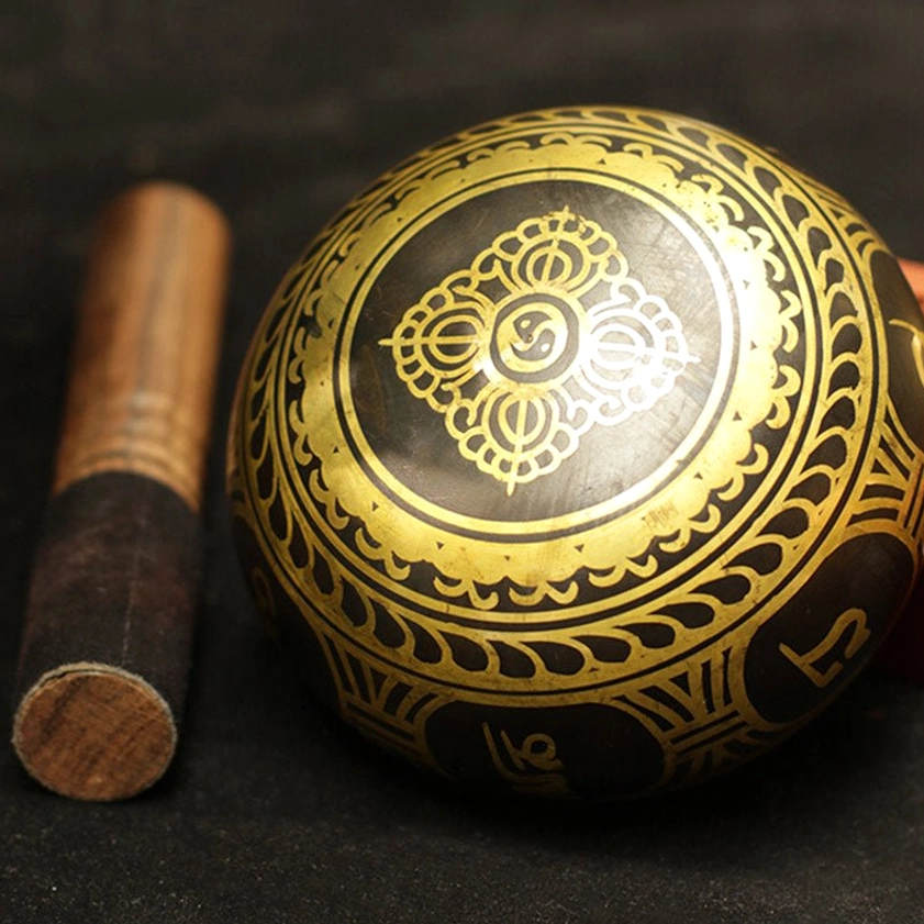 Buddhist singing bowl with gold Sanskrit inscriptions and decorative patterns for chakra healing and mindfulness meditation