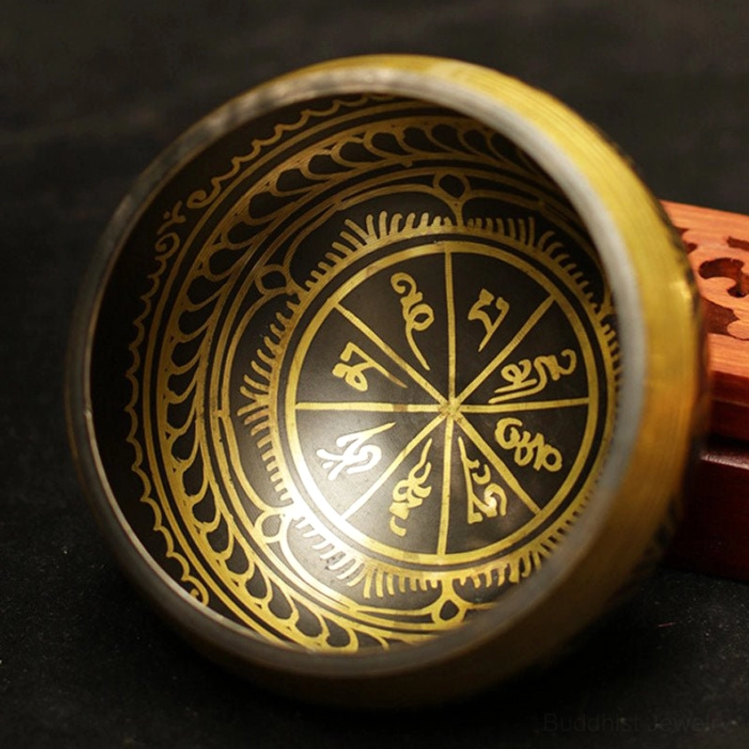 Handcrafted Buddhist singing bowl showing detailed inner surface with intricate gold Sanskrit scrollwork and decorative Buddhist patterns