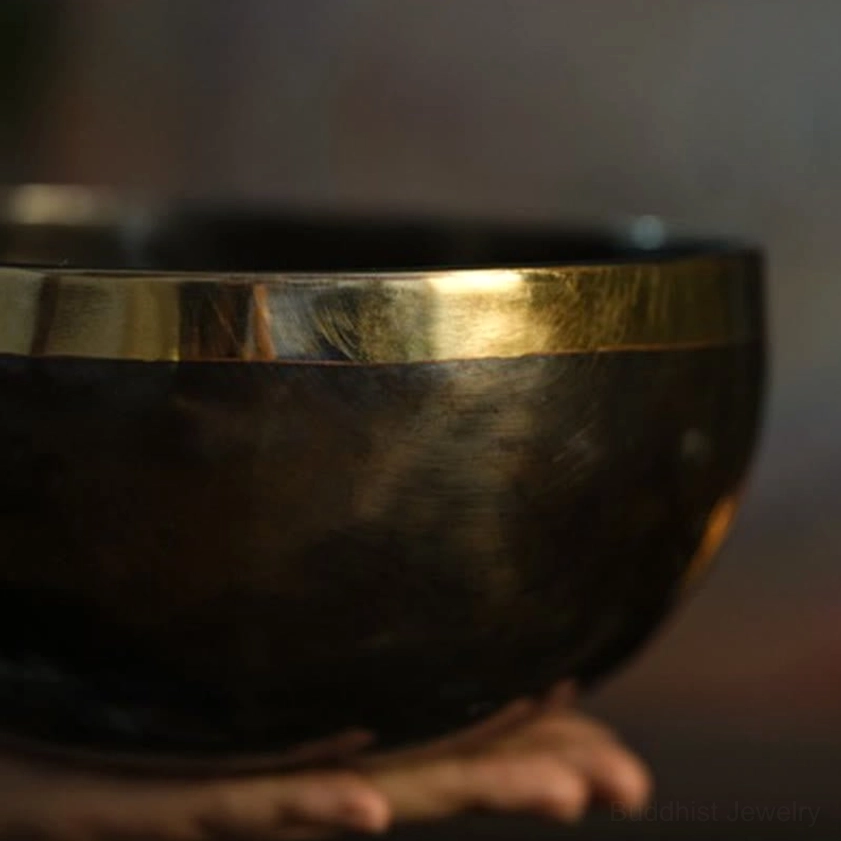 Handcrafted Buddhist meditation bowl showcasing dual-tone copper finish with dark body and luminous polished gold rim