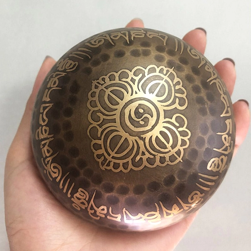 Buddhist singing bowl with unique floral sacred pattern, hammered bronze surface, engraved text on rim and body