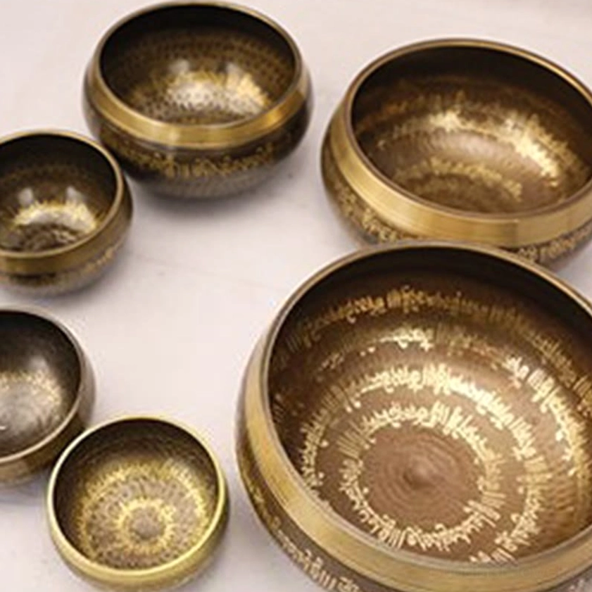 Handcrafted Buddhist singing bowl with visible Sanskrit mantras etched in golden finish on bronze body, authentic artisan craftsmanship details