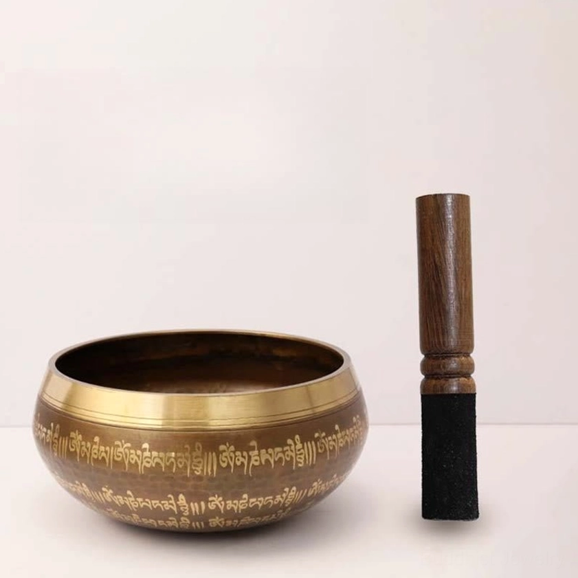 Buddhist singing bowl featuring sacred Sanskrit inscriptions and golden rim, handcrafted copper design for meditation and sound therapy wellness