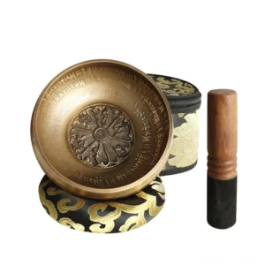 Handcrafted Buddhist singing bowl set with wooden mallet and embroidered storage case on white background
