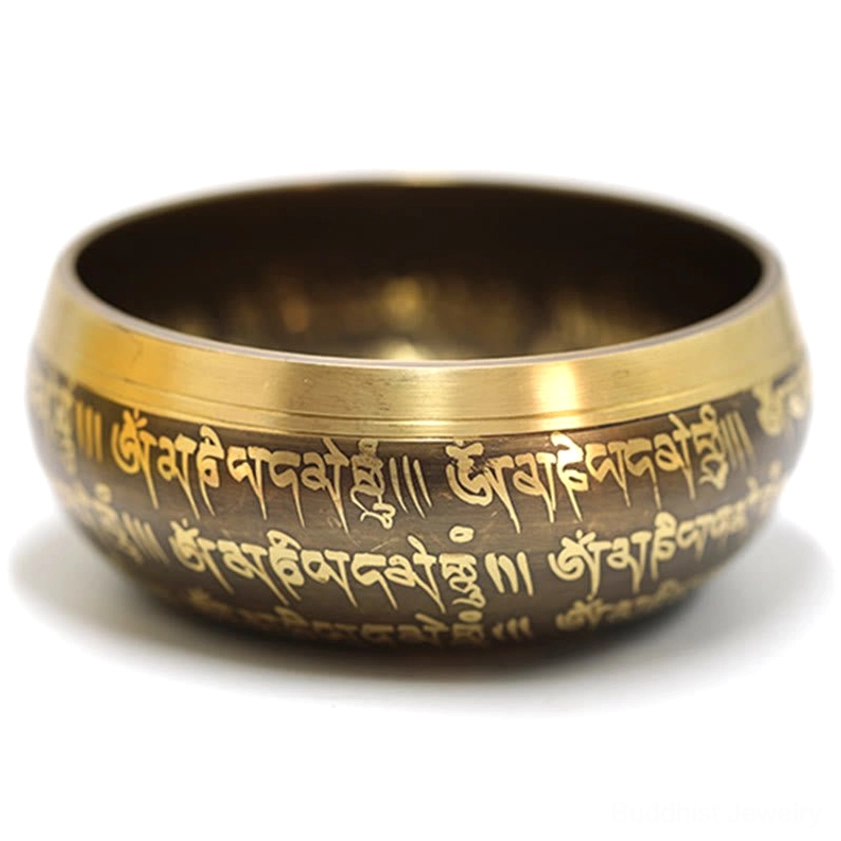 Side view of handcrafted Buddhist singing bowl with engraved Tibetan sutras and golden brass tone