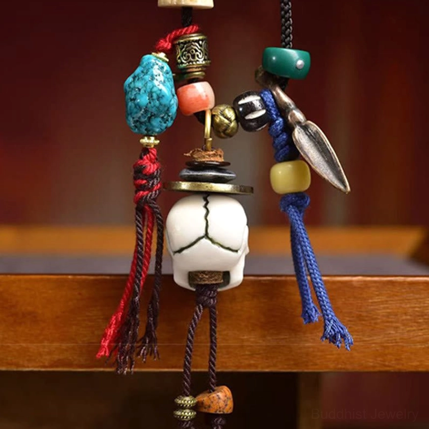 Side profile of skull pendant necklace showing blue tassel copper knife charm and turquoise beads