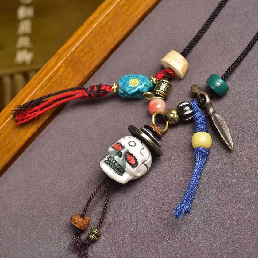 White bone skull charm with protective Buddhist design and colorful mixed beaded decorations