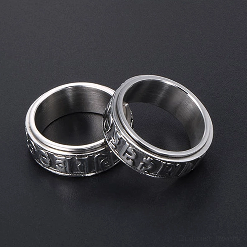 Two titanium steel mantra spinner rings with engraved Sanskrit characters, comparison view