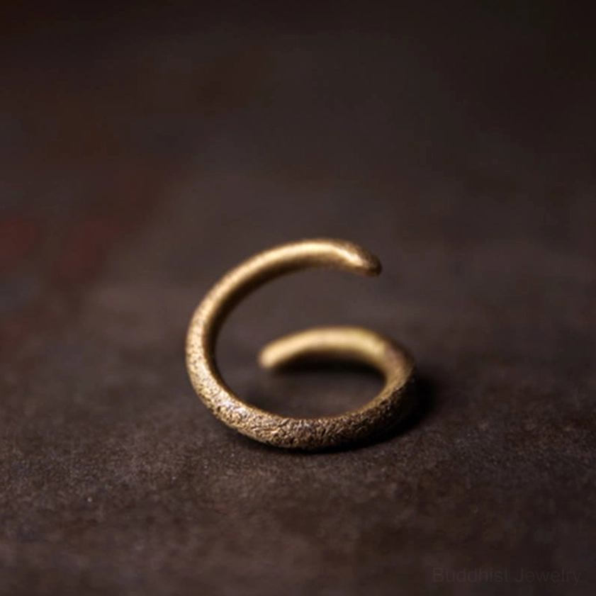 Closed spiral copper ring front oblique angle, rough textured bronze metal band
