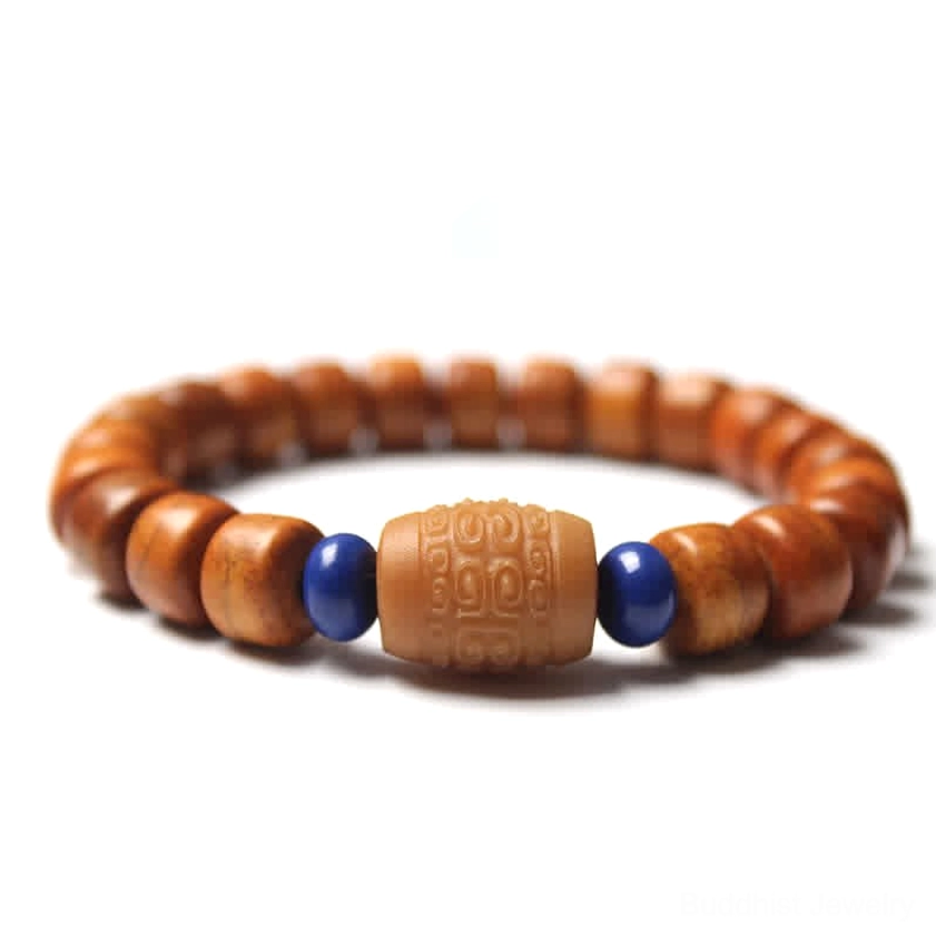 Buddhist spiritual bracelet with bone barrel beads, carved central charm and dark blue accent spacers