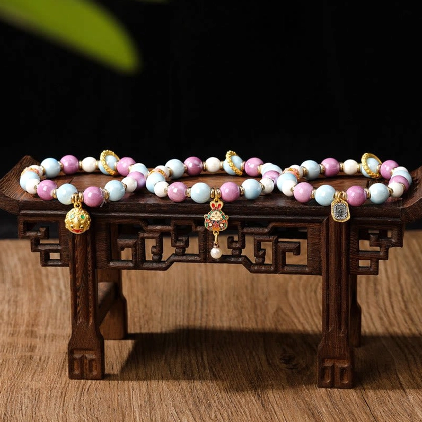 Buddhist bracelet with natural porcelain and liuli glass beads emphasizing spiritual symbolism for protection, prosperity, and inner peace