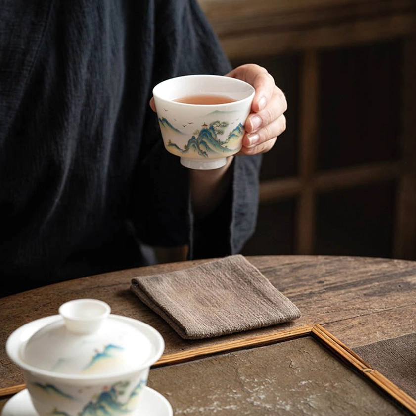 Artisan-crafted Buddhist ceramic tea cup with spiritual mountain scenery and traditional Eastern artistic design