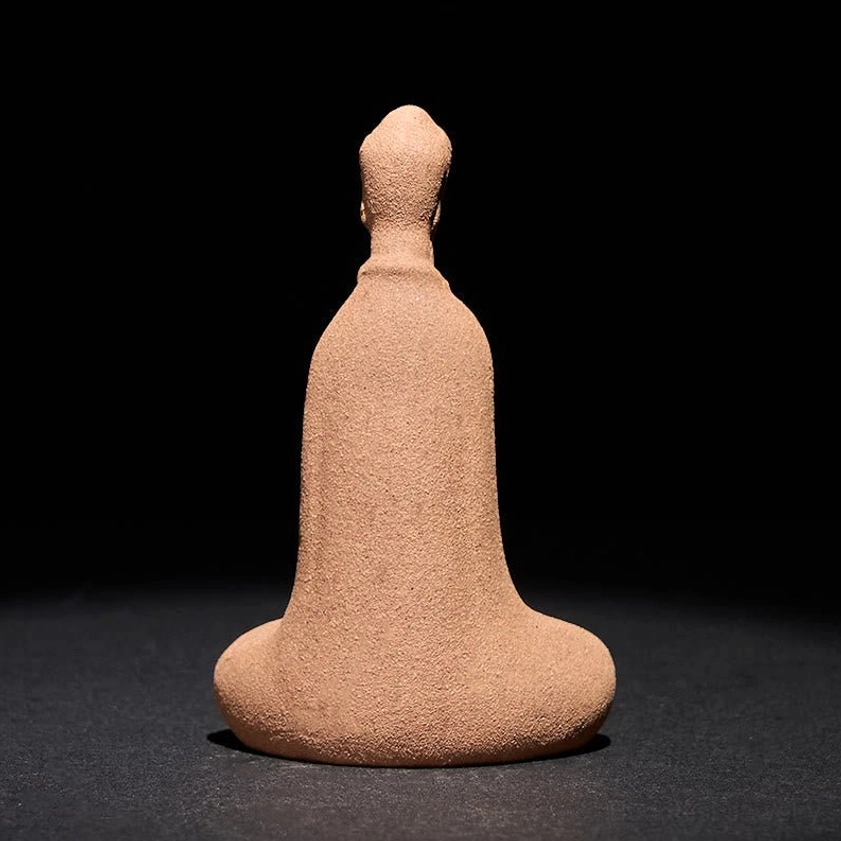 Rear view of handcrafted Buddha statue showing detailed back craftsmanship, uniform matte ceramic finish on tabletop