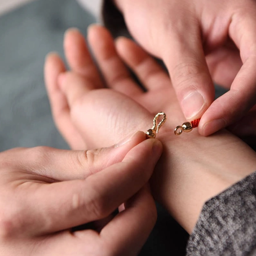 Demonstrating secure lobster clasp closure on handcrafted Buddhist luck bracelet