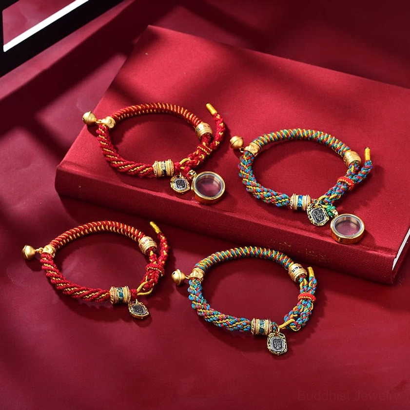 Two styles of handmade Buddhist prayer bracelets displayed with matching metal pendants and charm accessories on red silk