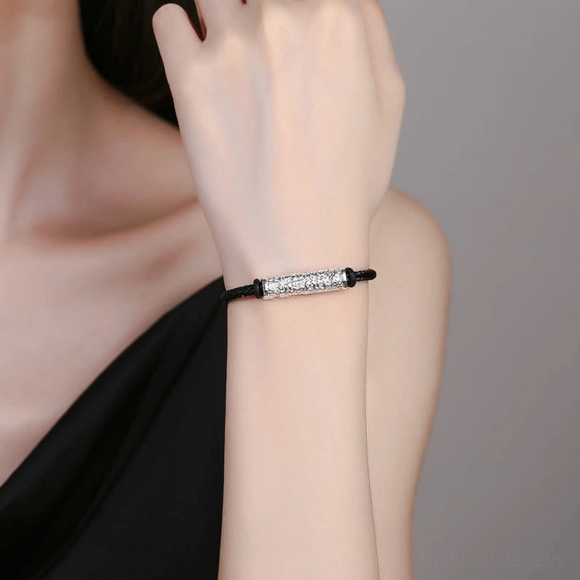 Black Buddhist braided string bracelet worn on wrist as minimalist spiritual jewelry lifestyle