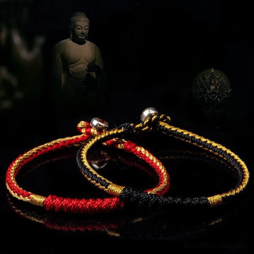 Two handmade Buddhist blessing bracelets in red-gold and black-gold styles with metal clasps, flat lay on dark Buddha-themed background