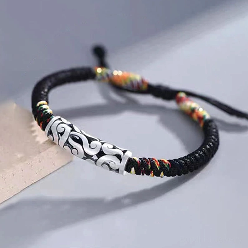 Buddhist luck string bracelet featuring engraved copper cloud bead with adjustable braided cord ends and colorful woven accents, side angle